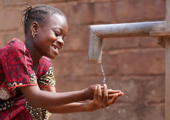 An African boy washing his hands.