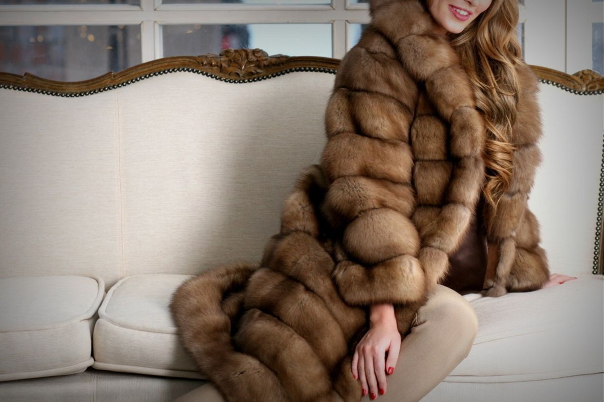 Woman in fur coat, close up, on the sofa, fur texture Woman in fur coat, close up, on the sofa, fur texture