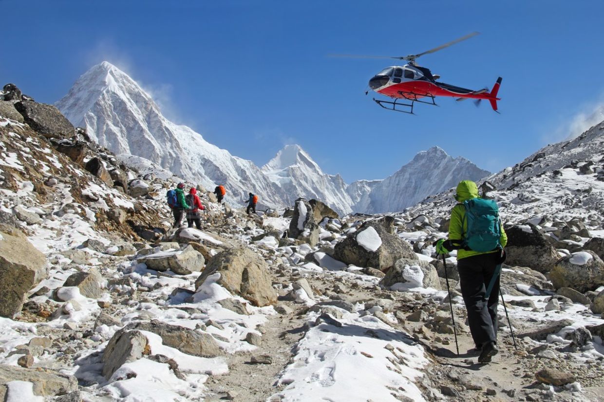 Goup of climbers in the Himalayas, view on peaks Lingtren, Pumori and Khumbutse. Rescue helicopter in action, Nepal Goup of climbers in the Himalayas, view on peaks Lingtren, Pumori and Khumbutse. Rescue helicopter in action, Nepal