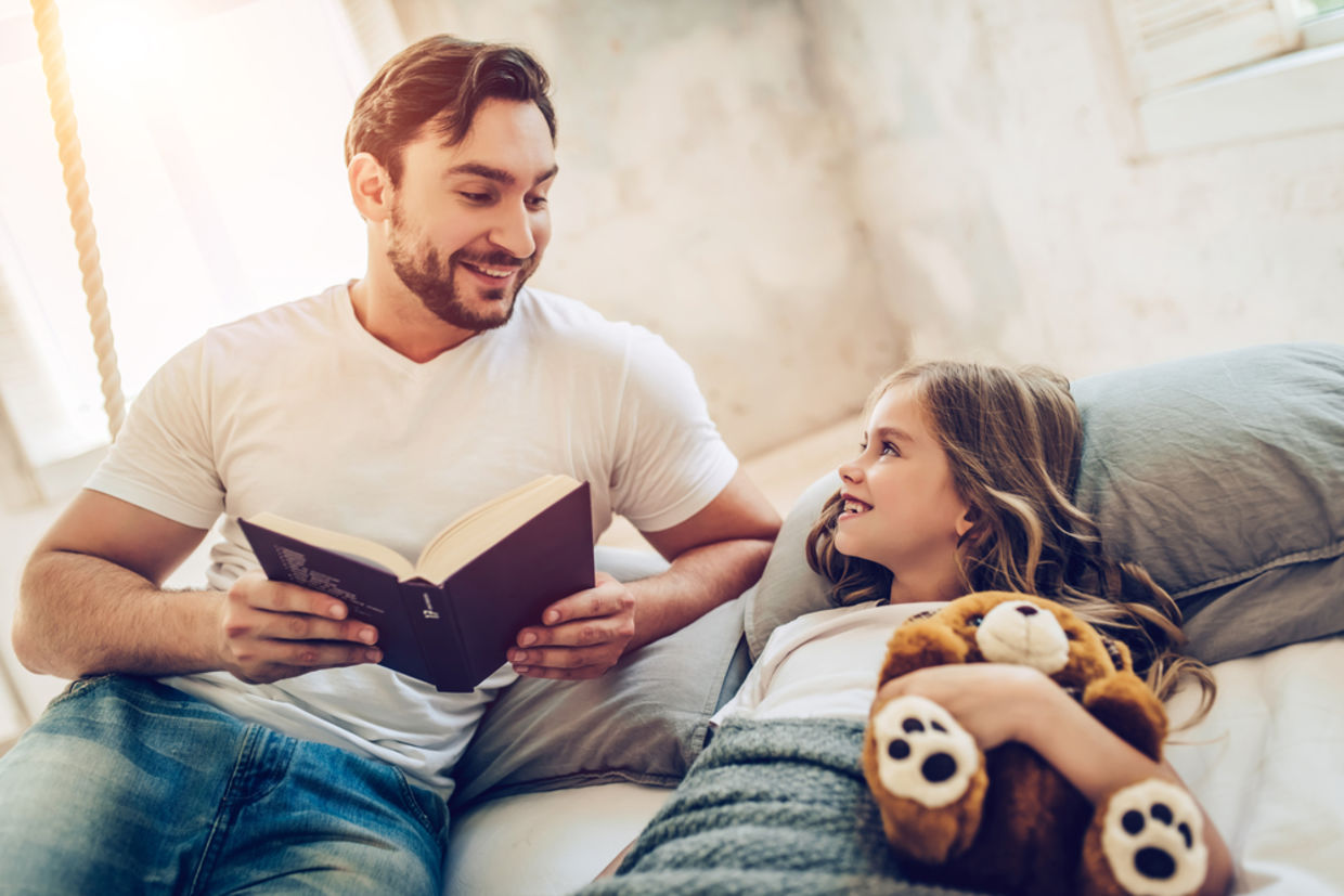 A father reads his daughter a bedtime story A father reads his daughter a bedtime story