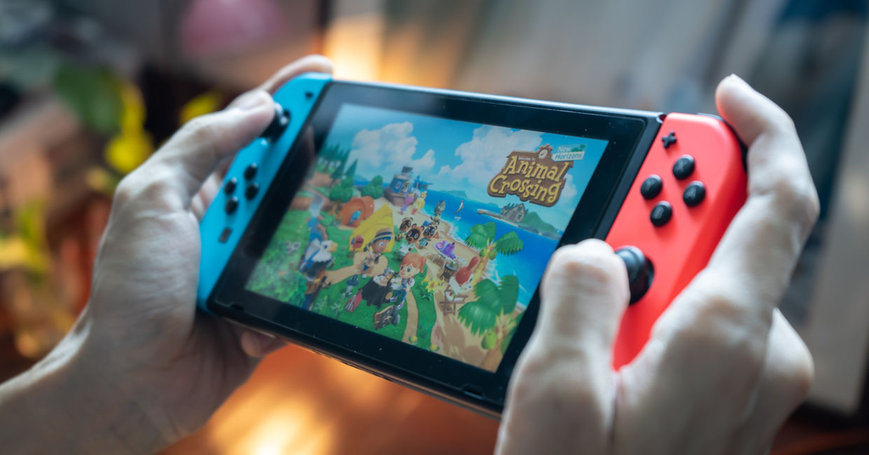 Man playing Animal Crossings on Nintendo Switch. Man playing Animal Crossings on Nintendo Switch.