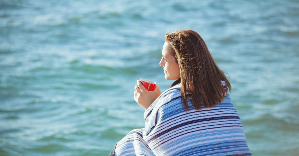 Woman sitting by the sea to manage stress Woman sitting by the sea to manage stress