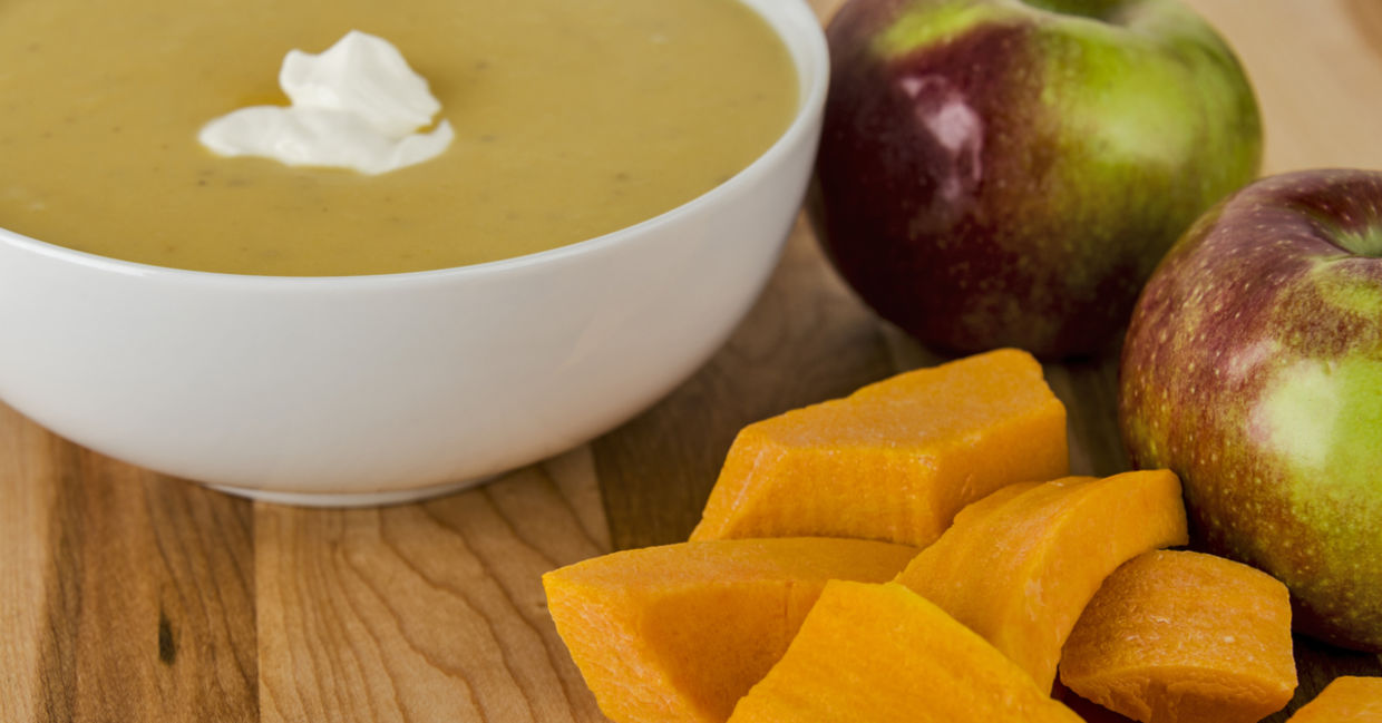 A bowl of butternut squash apple soup with McIntosh apples on the side. A bowl of butternut squash apple soup with McIntosh apples on the side.