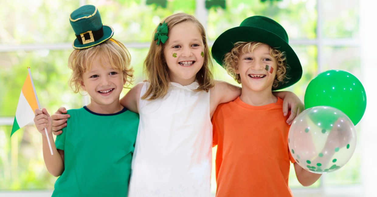 Children celebrate St. Patrick's Day by wearing a leprechaun hat and waving an Irish flag. Children celebrate St. Patrick's Day by wearing a leprechaun hat and waving an Irish flag.