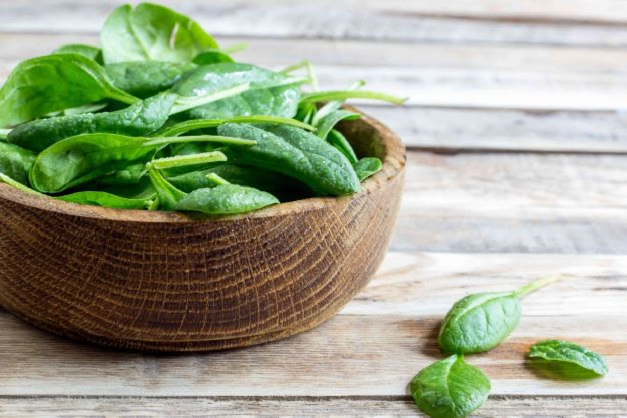 Fresh baby spinach in a wooden ball