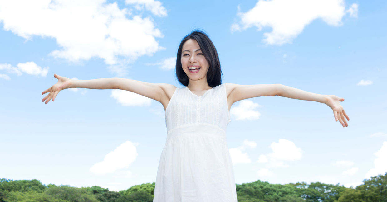 A woman happily embraces a sunny summer’s day. A woman happily embraces a sunny summer’s day.