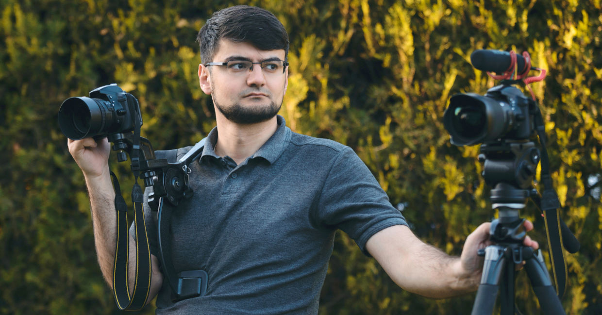 A videographer with two cameras. A videographer with two cameras.
