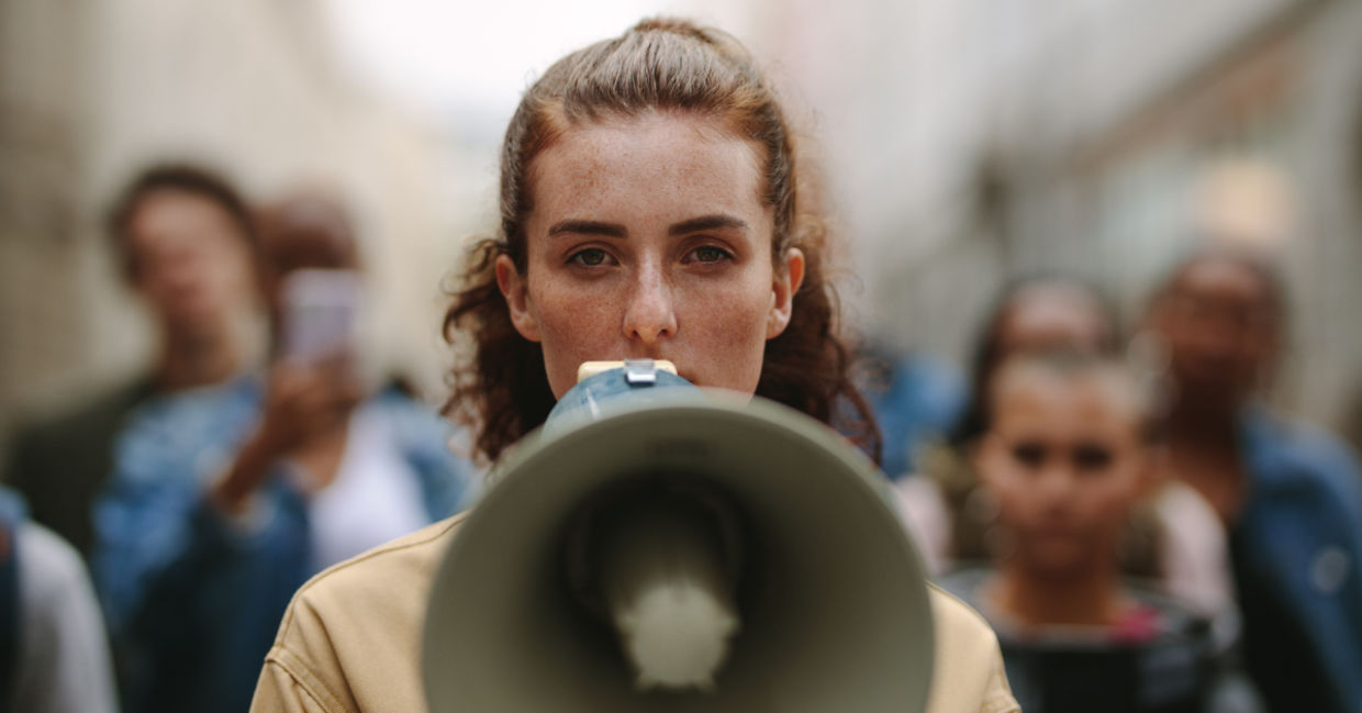 A woman protesting with a megaphone. A woman protesting with a megaphone.