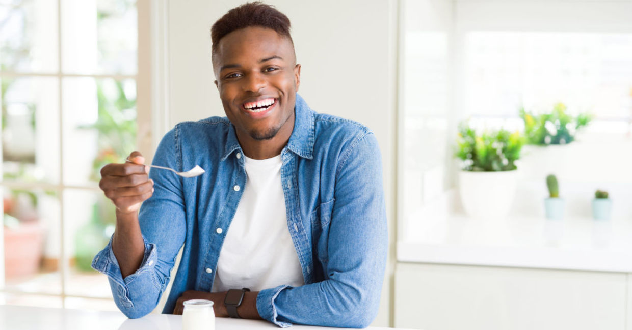 A man is eating sugar-free yogurt. A man is eating sugar-free yogurt.