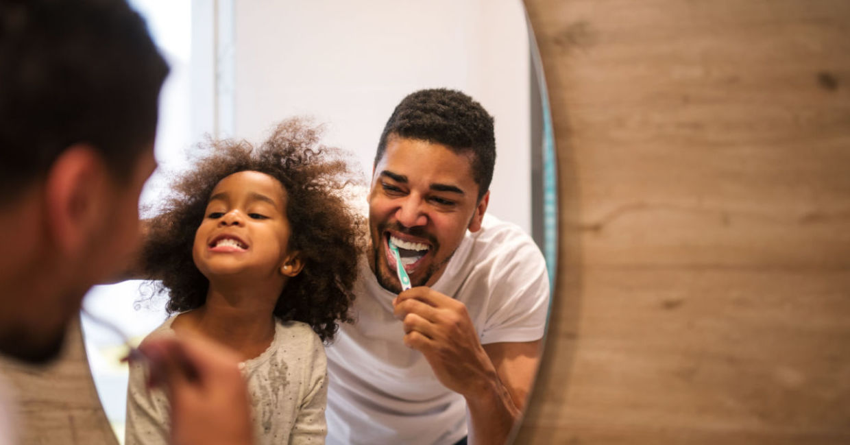 A woman looks in the mirror as she brushes her teeth. A woman looks in the mirror as she brushes her teeth.