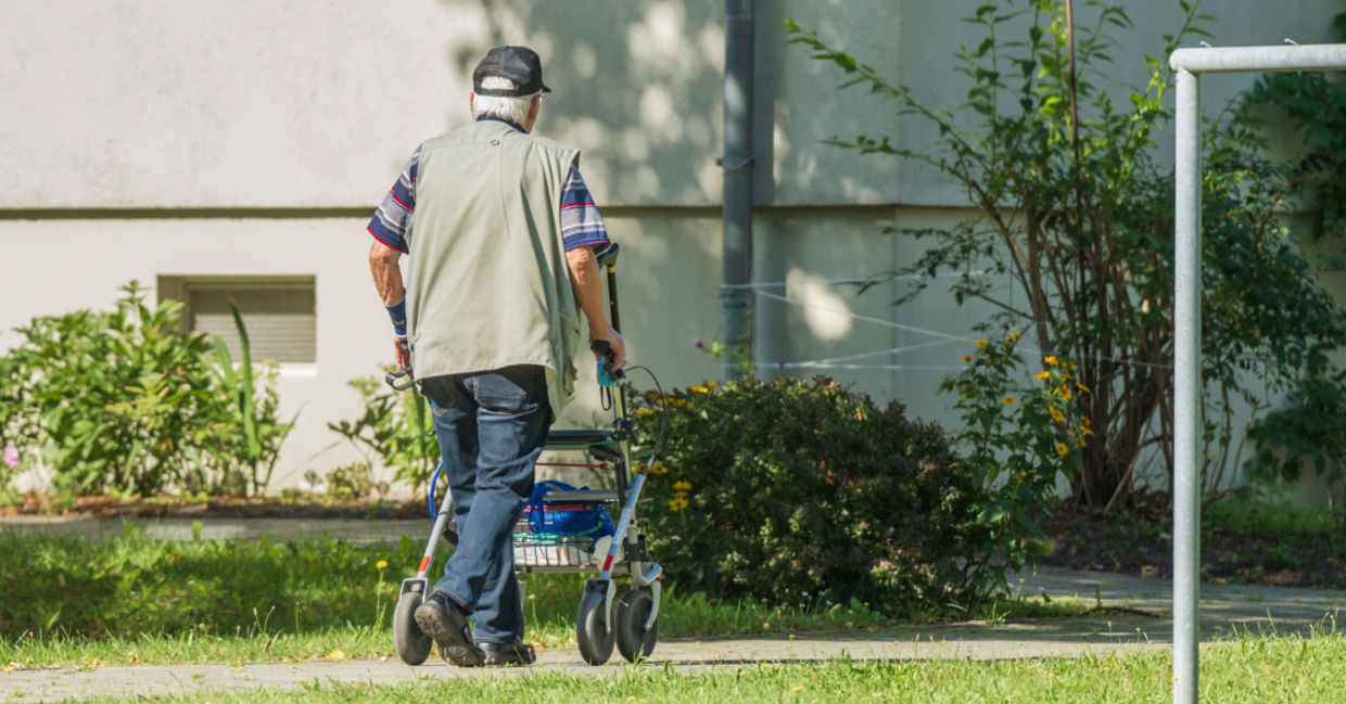 Senior man walking in his yard. Senior man walking in his yard.