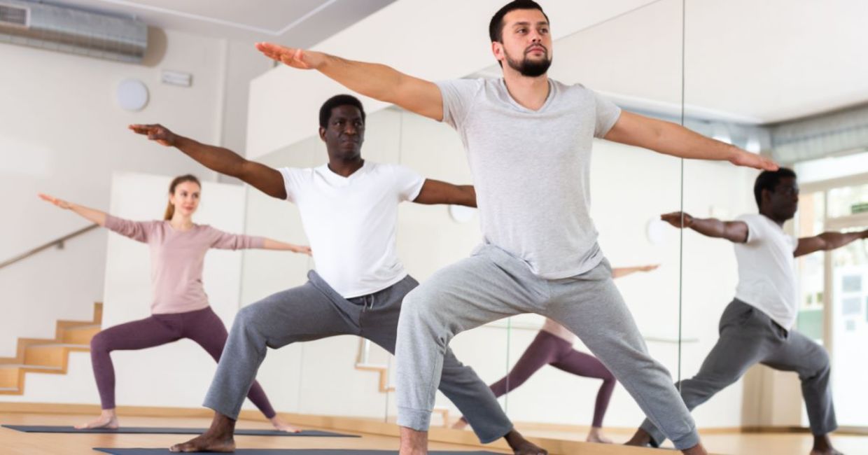 Men performing the Warrior II yoga pose. Men performing the Warrior II yoga pose.