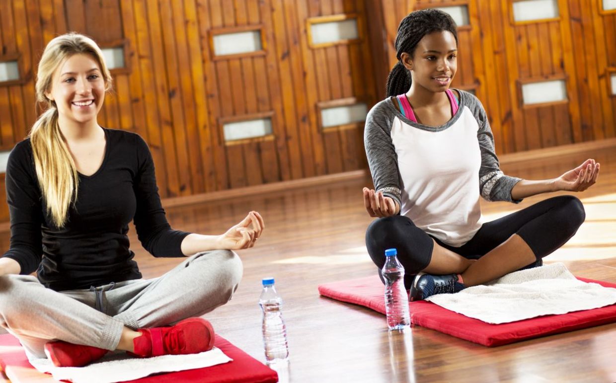 Teenage girls beginning a yoga session. Teenage girls beginning a yoga session.