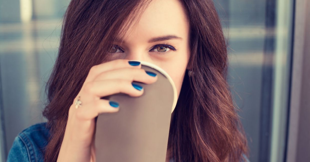 Smiling woman drinking coffee from a paper cup. Smiling woman drinking coffee from a paper cup.