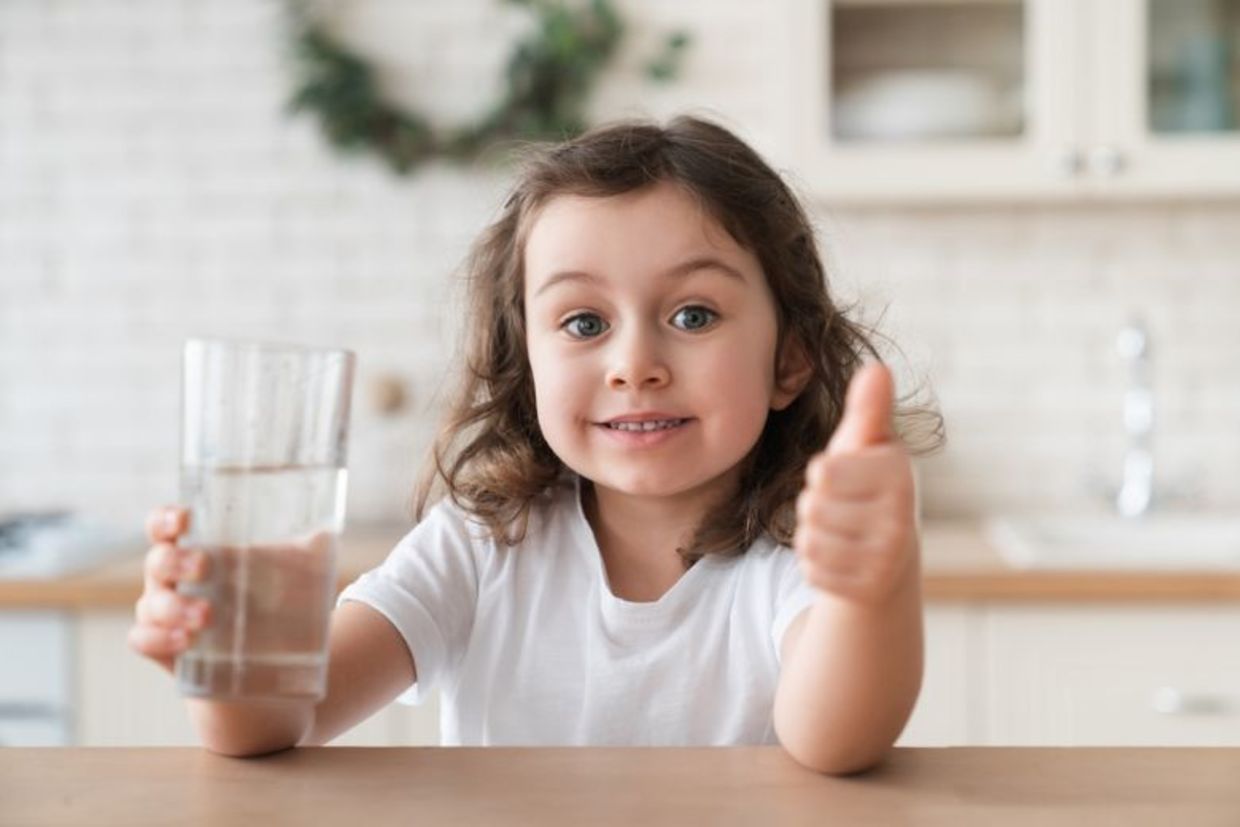 A cute girl enjoying a glass of fresh water. A cute girl enjoying a glass of fresh water.