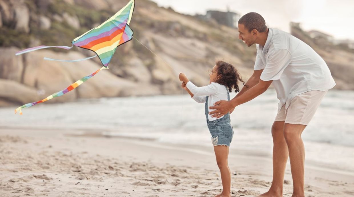 A father and daughter flying a kite. A father and daughter flying a kite.