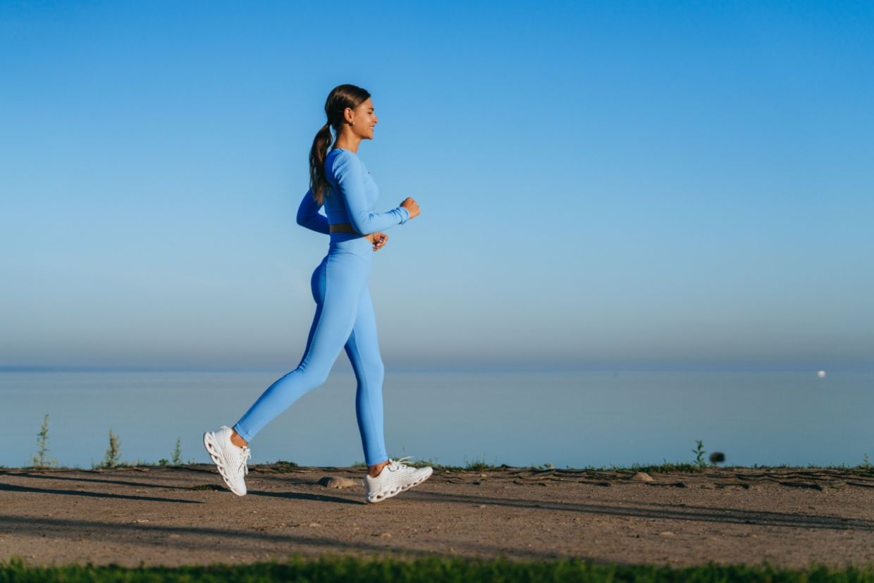 A woman walks along a waterside path. A woman walks along a waterside path.