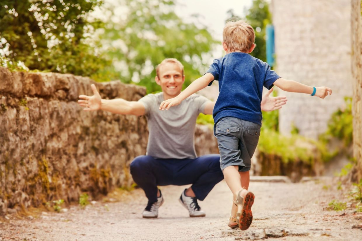 A boy runs into his father’s arms. A boy runs into his father’s arms.